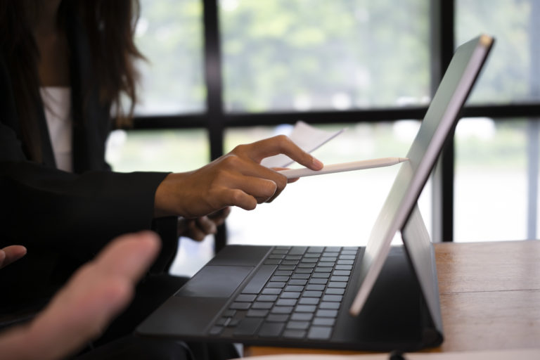 Hands working on a laptop and tablet